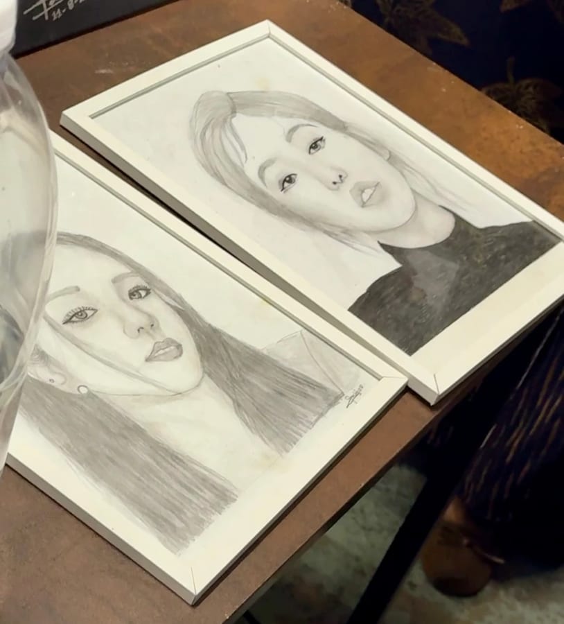 Two framed pencil portrait drawings made by students